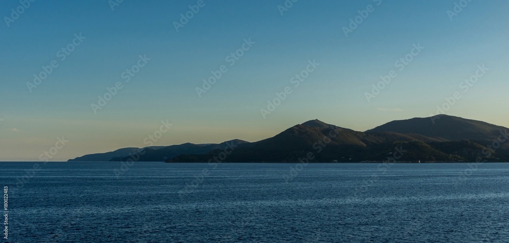 View on few cliffs of Elba island from the sea in evening light View on few cliffs of Elba island from the sea in evening light