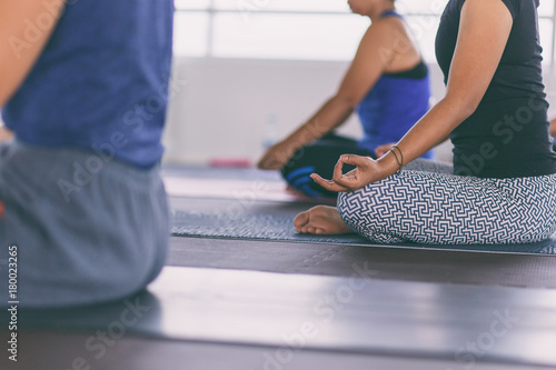 Women in meditation while practicing yoga in a training room. Happy, calm and relaxing.