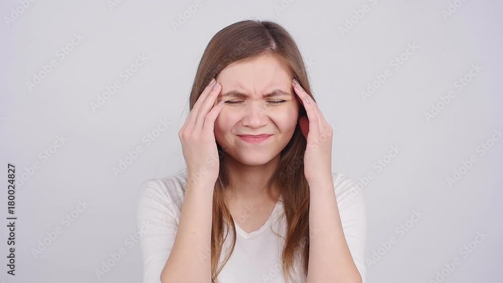 Young woman has headache, isolated on gray background Young woman has headache, isolated on gray background