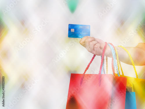 Blurred image, shopping concept with woman hand holding credit card and shopping bag, celebration background