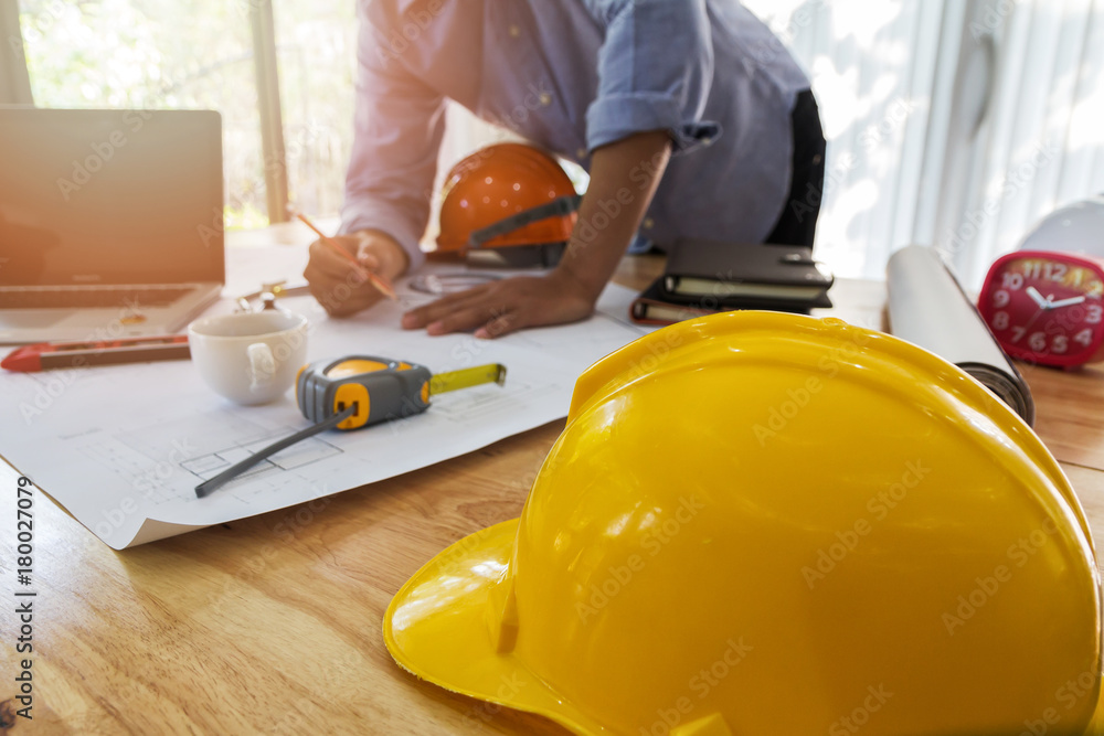 helmet on wooden desk with architect background helmet on wooden desk with architect background