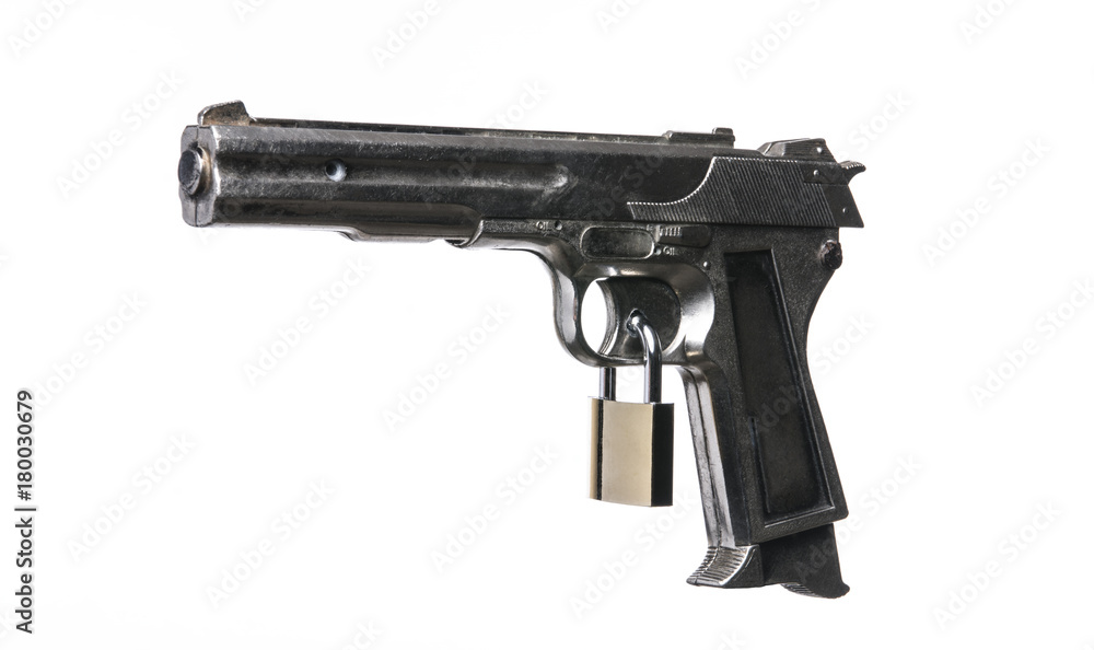 Locked handgun with a padlock on the trigger. Isolated on white background. With copy space text. Studio Shot. Locked handgun with a padlock on the trigger. Isolated on white background. With copy space text. Studio Shot.