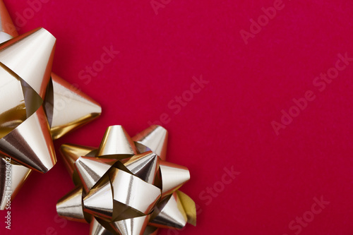 Tableau sur toile Metallic gift bow on a red background
