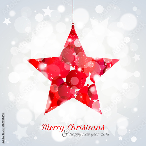 Christmas card with hanging red star on bokeh