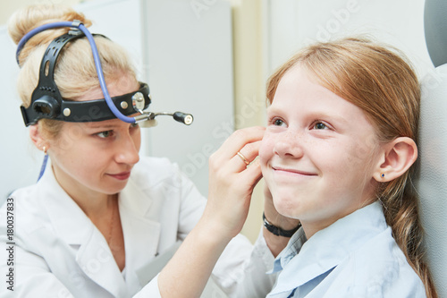 female doctor of ENT ear nose throat at work examining girl ear photo