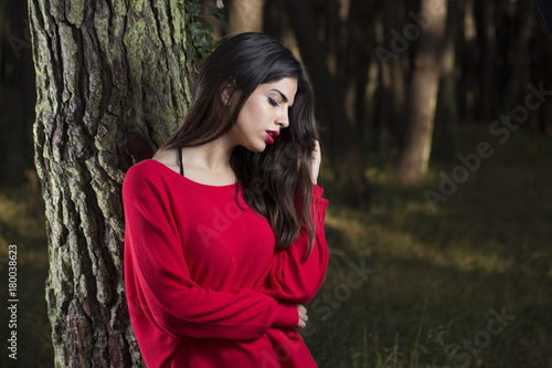 Portrait of young beautiful woman with long hair outdoors in the forest