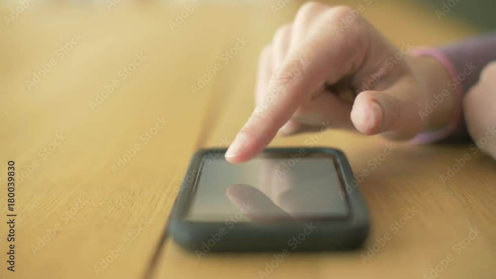 Woman Scrolling Web Pages On Smartphone At Table Woman Scrolling Web Pages On Smartphone At Table