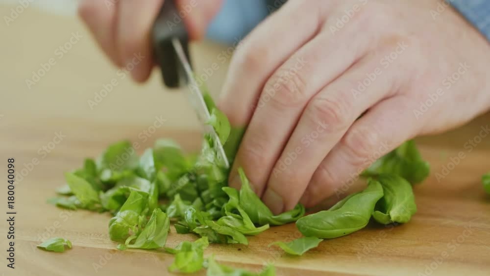 Man's Hands Cutting Basil Leaves With Knife On Chopping Board Man's Hands Cutting Basil Leaves With Knife On Chopping Board
