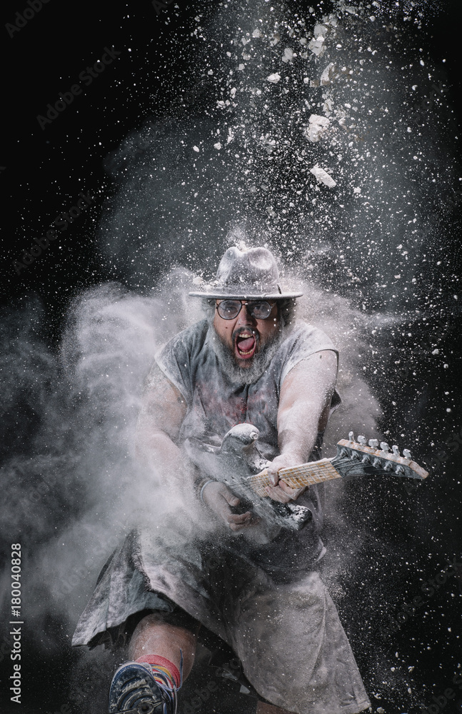 Fototapeta premium man with the guitar between chalk dust and smoke