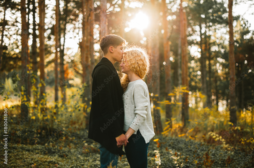 romantic couple kissing at sunset in coniferous forest romantic couple kissing at sunset in coniferous forest