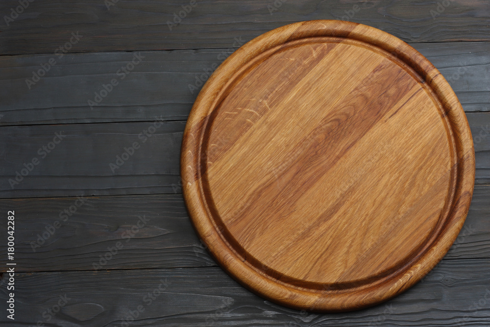 round wooden plate on dark wooden background top view round wooden plate on dark wooden background top view