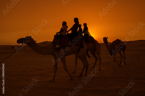 Silhouette of people on a camel