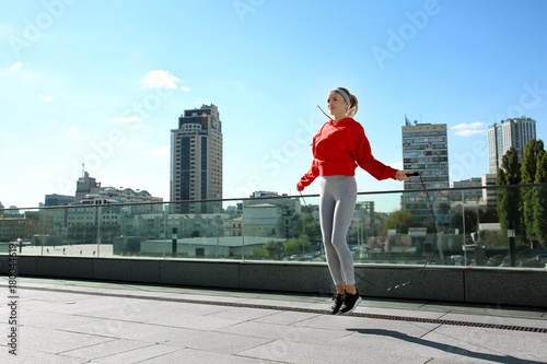 Sporty young woman jumping ...