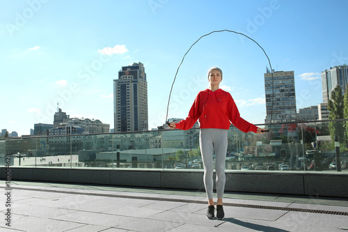 Sporty young woman jumping ...