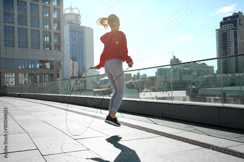 Sporty young woman jumping ...