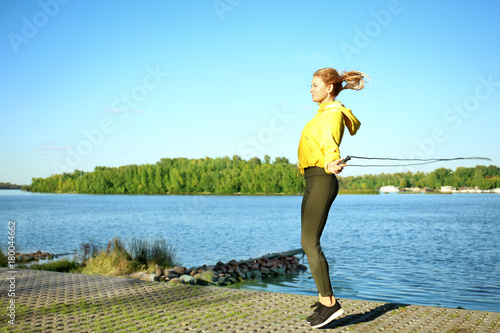 Sporty young woman jumping ...