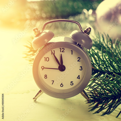 Grey Christmas alarm clock showing midnight, new years eve with decorations on white background