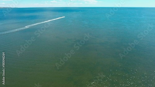 Water scooter move away to beach, aerial wide angle shot. photo