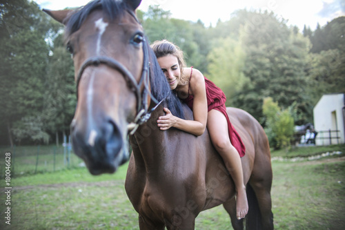 Beautiful girl stroking her horse