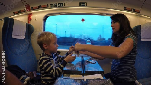 A young mother and her son travel by train.
Woman and child playing card games while traveling on the train.