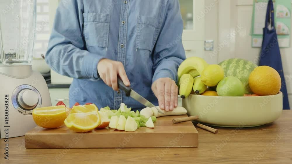Woman Slicing Banana And Apple With Knife On Cutting Board