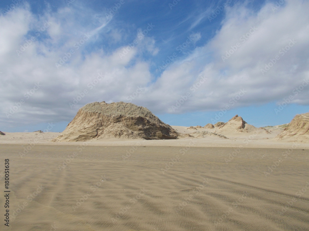 Dune formation atNinety mile Beach with clouds in the sky on North Island in New Zealand