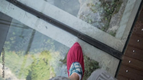 POV view of the legs in red boot covers walking along sgass sky walk at Tianmenshan National Park in China