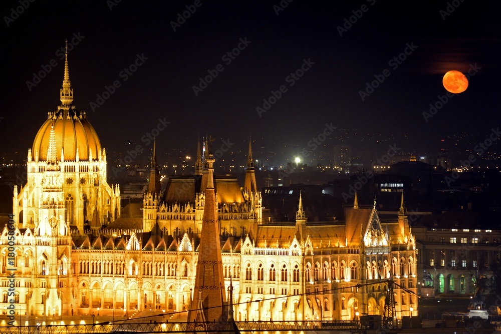 Obraz premium The parliament building at night with red moon, Budapest, Hungar