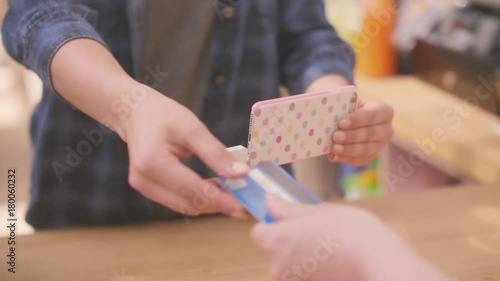Deli Owner Receiving Payment Through Credit Card Connected To Smartphone