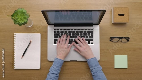 Overhead Of Woman Using Laptop At Wooden Desk