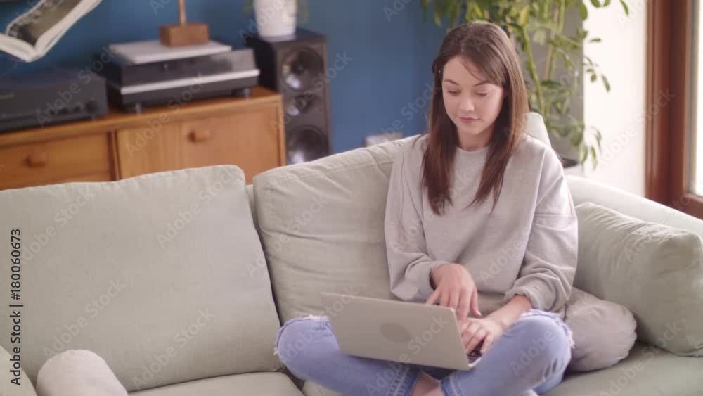 Beautiful Female Blogger Using Laptop While Sitting On Sofa At Home Beautiful Female Blogger Using Laptop While Sitting On Sofa At Home