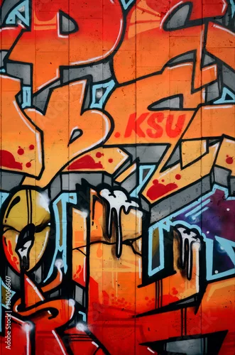 Obraz Fragment szczegółowego graffiti rysunku wykonanego farbami w aerozolu na ścianie z betonowych płytek. Obraz w tle sztuki ulicznej w ciepłych odcieniach czerwonego koloru