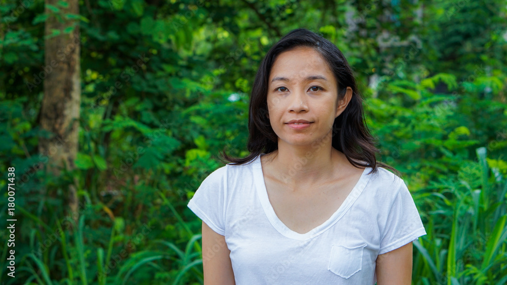 Asian woman long hair with facial epression green nature background Asian woman long hair with facial epression green nature background