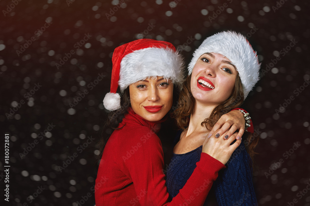 Young woman in Santa hat on a dark background Young woman in Santa hat on a dark background