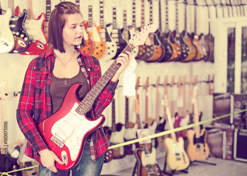Teenage girl choosing electric guitar