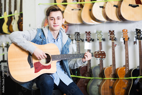 Teenager choosing acoustic guitars