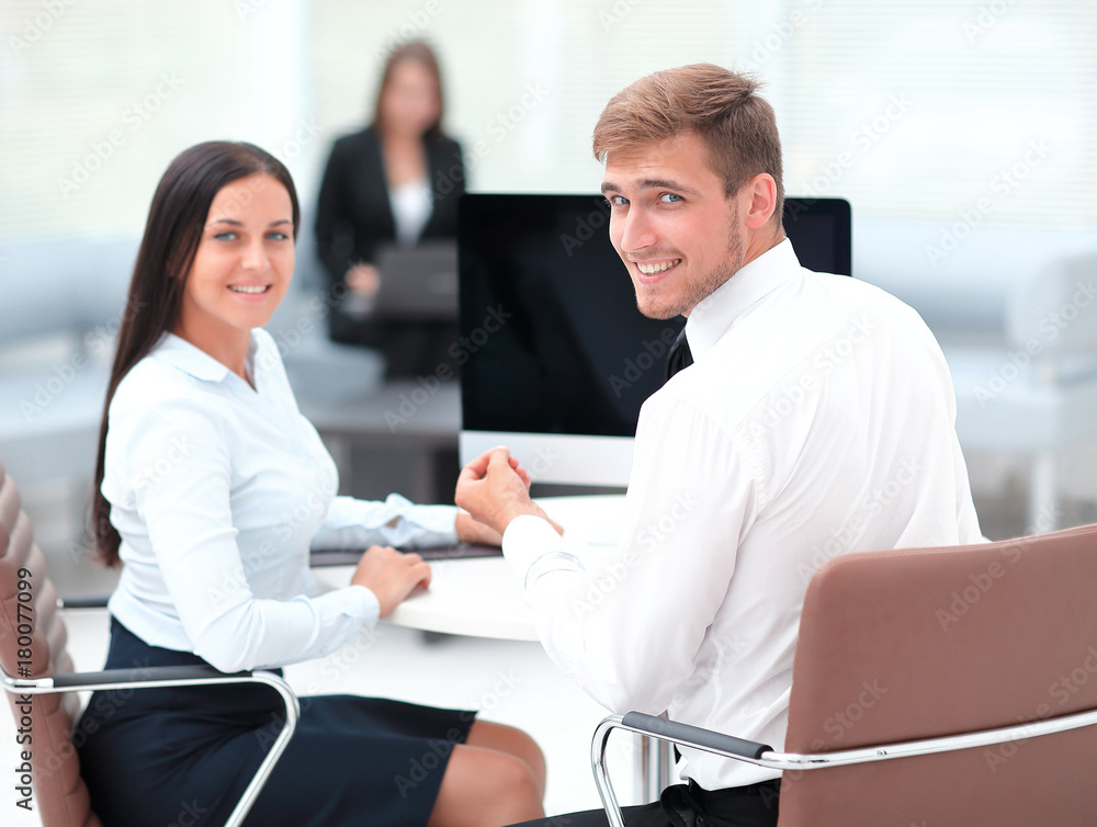 members of the business team sitting at Desk and looking at camera . members of the business team sitting at Desk and looking at camera .