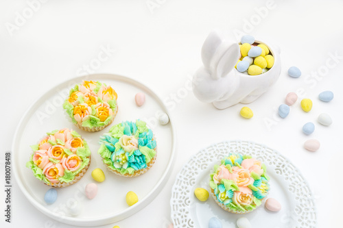 Easter theme decorated cupcakes on white Background with a bunny.