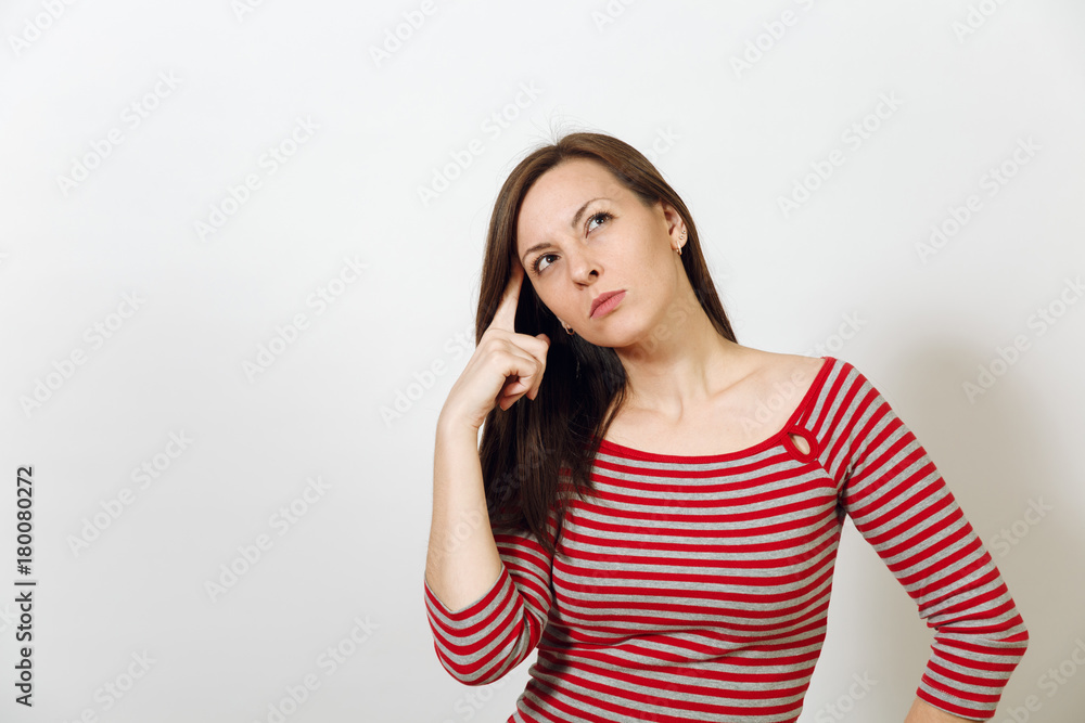 Pretty European young worried and pensive brown-haired woman with healthy clean skin, dressed in casual red and grey clothes lost in thought and conjectures, on a white background. Emotions concept. Pretty European young worried and pensive brown-haired woman with healthy clean skin, dressed in casual red and grey clothes lost in thought and conjectures, on a white background. Emotions concept.