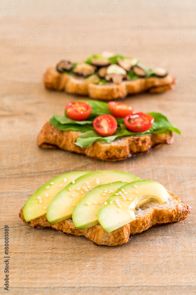 croissant sandwich with avocado, tomatoes and mushroom