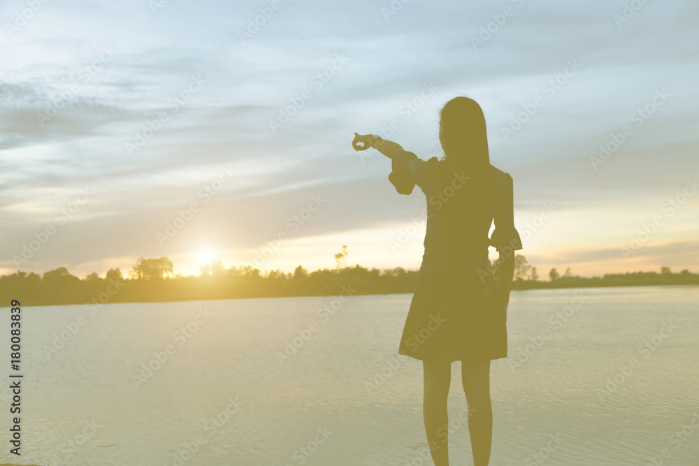 Fototapeta premium Silhouette of woman praying over beautiful sky background