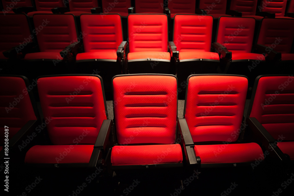 Fototapeta premium Red seat in the movie theater. Blurry background.