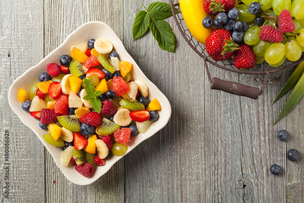 Delicious fruit salad with fresh fruit. Wooden, gray table in the background. Delicious fruit salad with fresh fruit. Wooden, gray table in the background.