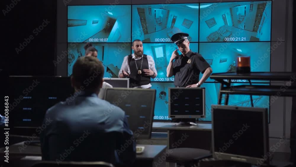 Professional team of policemen taking care of alert signal while watching video from security camera. Professional team of policemen taking care of alert signal while watching video from security camera.