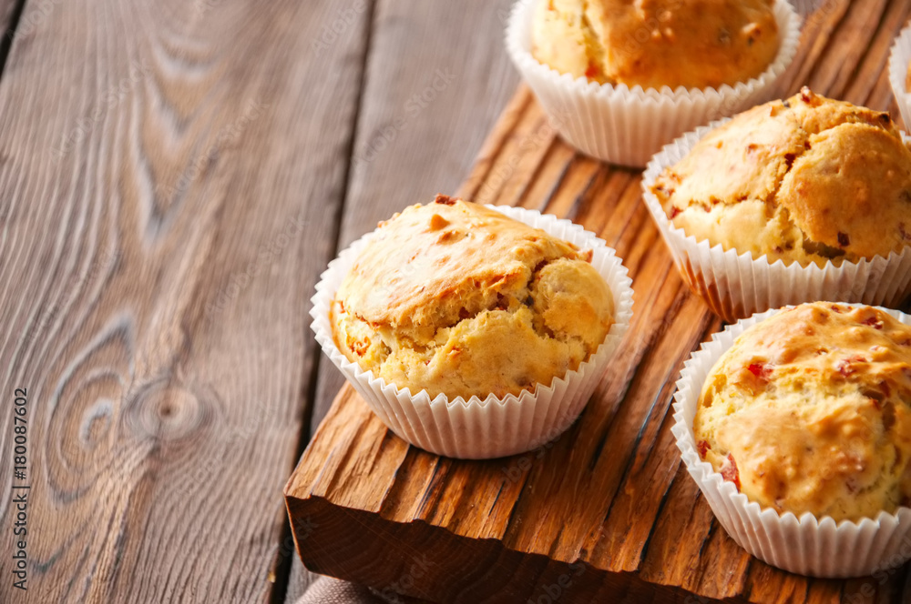 Homemade muffins with bacon and cheese on a wooden background. Healthy snack or breakfast meal. Homemade muffins with bacon and cheese on a wooden background. Healthy snack or breakfast meal.