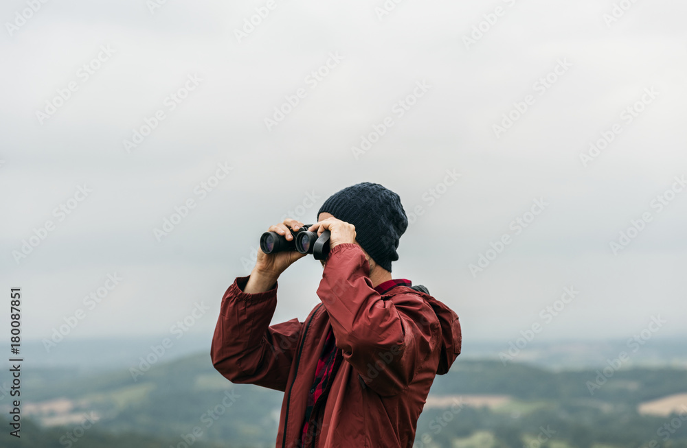 Obraz premium Side view of man using binocular