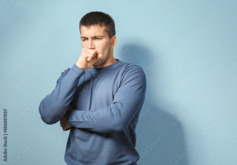 Young ill man against color background