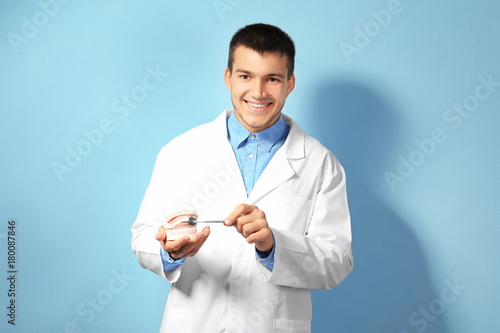 Young male dentist with jaw...