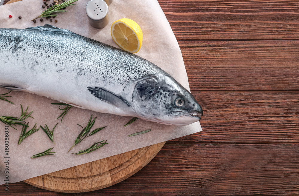 Board with fresh raw salmon on wooden table Board with fresh raw salmon on wooden table