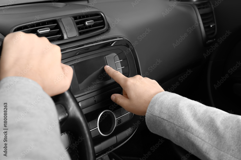 Man tuning radio in car Man tuning radio in car